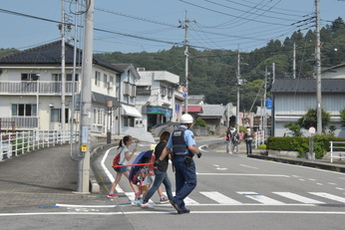 避難訓練の大雨を想定して傘をさして避難する住民